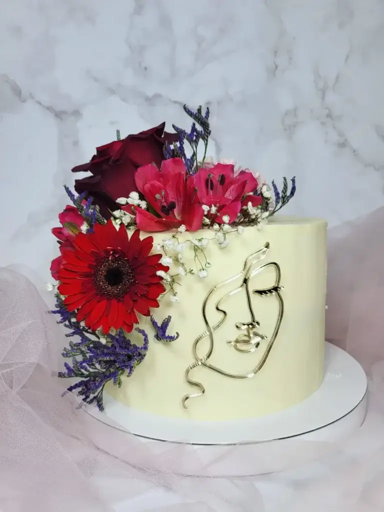 Elegancki tort z motywem złotej linii i dekoracją z czerwonych kwiatów oraz lawendy