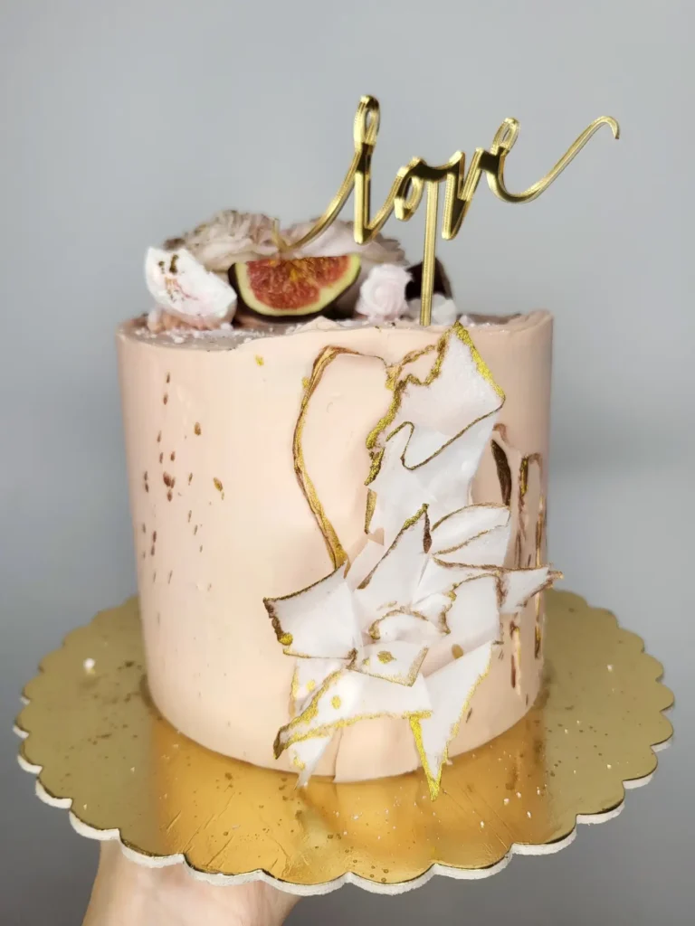 Tort na rocznice ślubu z złotym toperem love, świeżymi figami oraz kwiatami