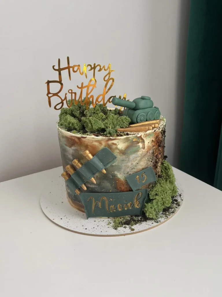 Tort urodzinowy na piętnaste urodziny Maćka, ozdobiony czołgiem skrytym w krzakach wykonany z masy cukrowej oraz pociskami.